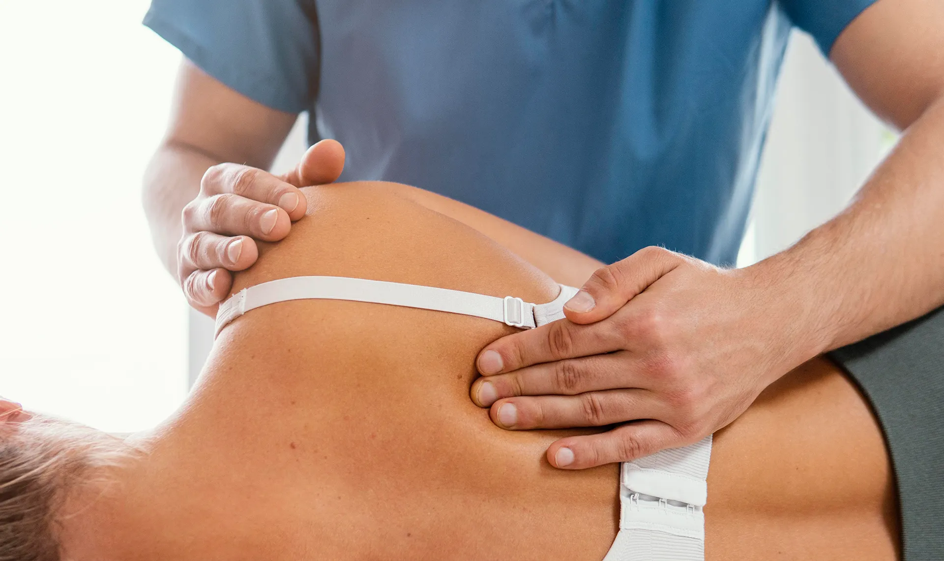 Lady with back pain being examined by physiotherapist ready for EMS treatment